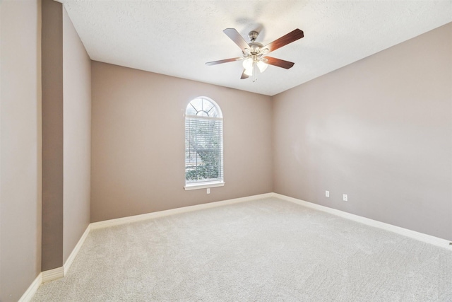 carpeted empty room featuring a ceiling fan, baseboards, and a textured ceiling