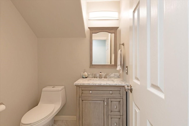 half bathroom featuring vanity, toilet, and baseboards