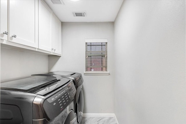 washroom with visible vents, baseboards, cabinet space, marble finish floor, and independent washer and dryer