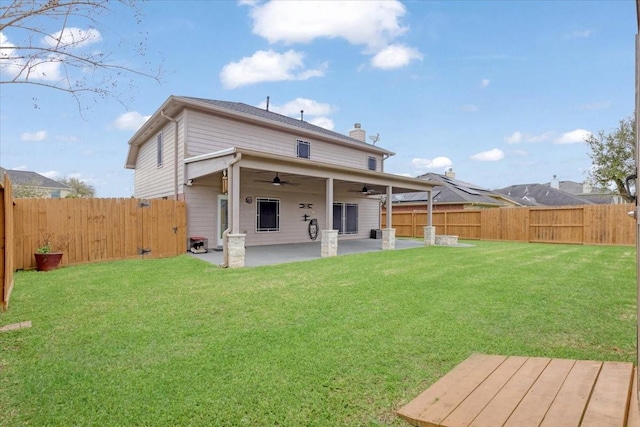 rear view of house with a yard, a fenced backyard, and a ceiling fan