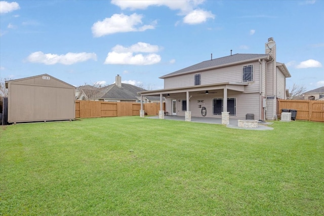 back of house with a storage unit, a ceiling fan, a fenced backyard, an outdoor structure, and a patio area