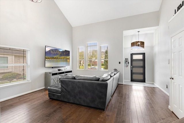 living area with plenty of natural light, high vaulted ceiling, and dark wood-type flooring