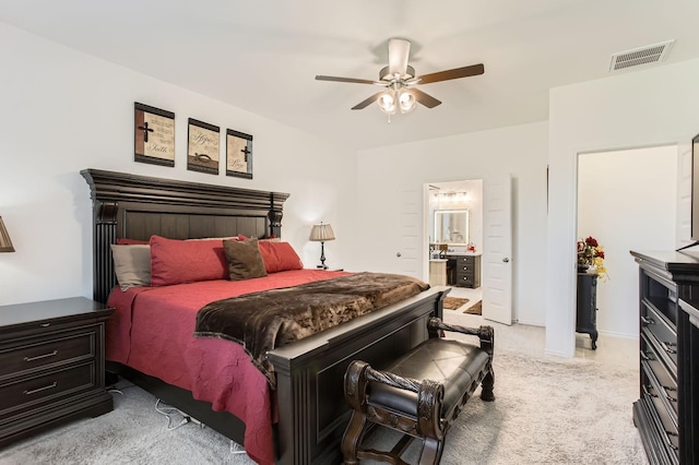 bedroom with visible vents, light colored carpet, ensuite bathroom, and ceiling fan