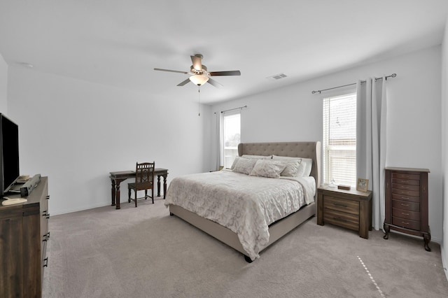 carpeted bedroom featuring visible vents, baseboards, and ceiling fan