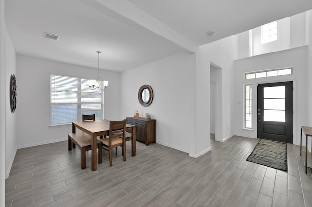 dining space with an inviting chandelier, baseboards, visible vents, and wood finish floors