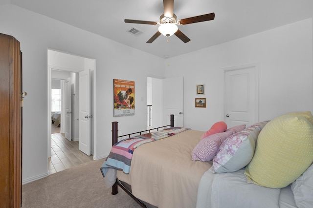 bedroom featuring visible vents, light carpet, and ceiling fan