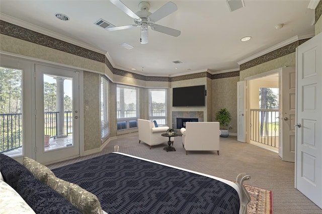 carpeted bedroom featuring multiple windows, a tiled fireplace, crown molding, wallpapered walls, and access to exterior