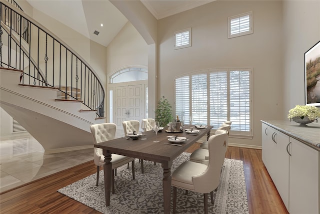 dining area with a wealth of natural light, stairway, and light wood-type flooring