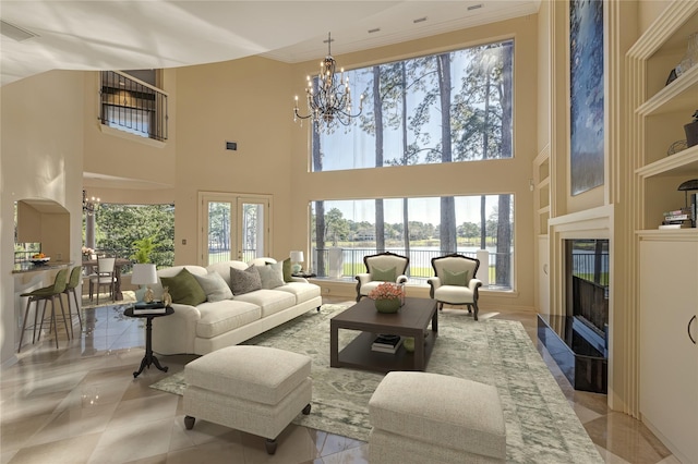 living room with a notable chandelier, plenty of natural light, a fireplace with flush hearth, and a water view