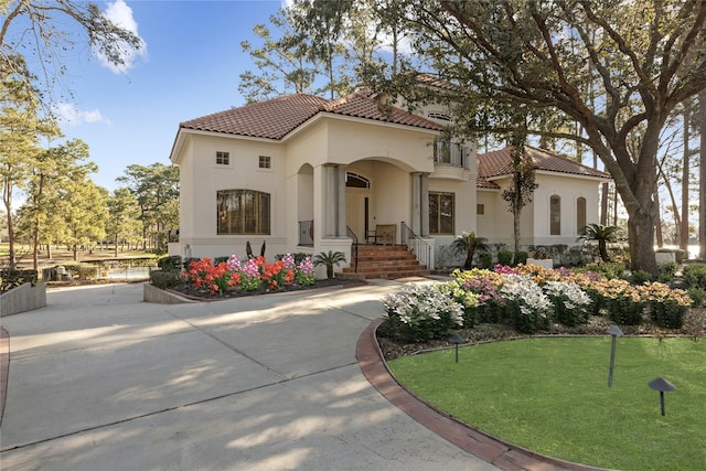 mediterranean / spanish home featuring stucco siding and a tile roof