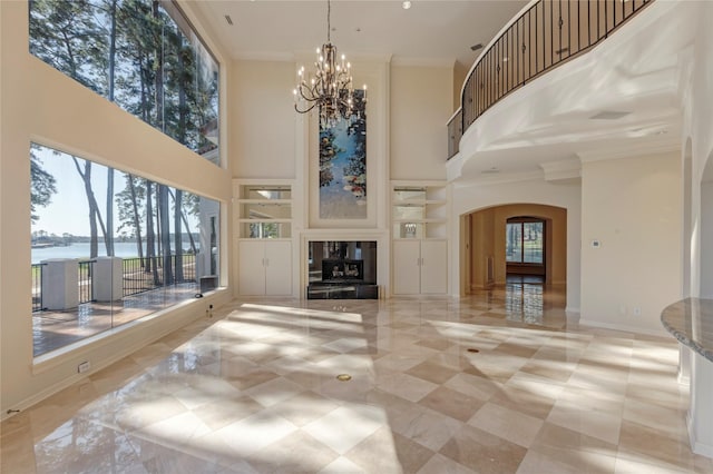 living area with built in shelves, crown molding, baseboards, a multi sided fireplace, and arched walkways