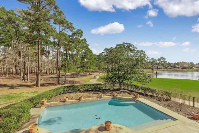 view of swimming pool featuring a lawn, fence, and a water view