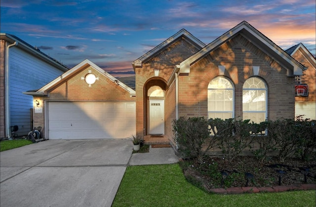 view of front of property featuring a garage, brick siding, and driveway