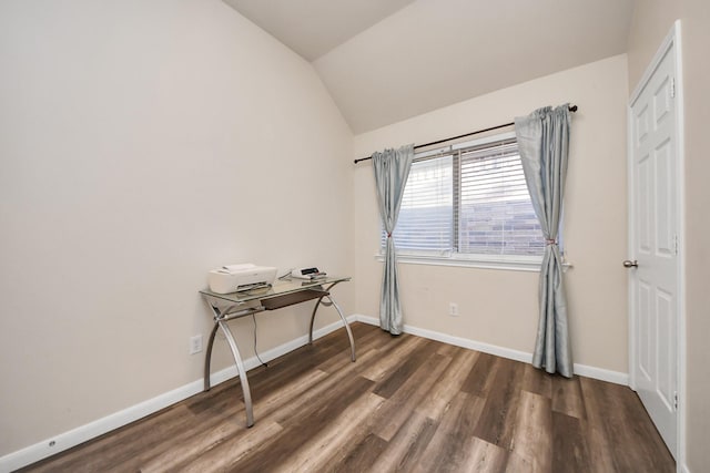 unfurnished room with wood finished floors, baseboards, and vaulted ceiling