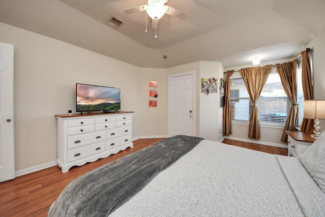 bedroom featuring a ceiling fan, wood finished floors, visible vents, and baseboards