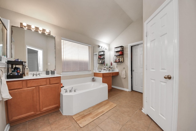 full bathroom with vanity, vaulted ceiling, a bath, and tile patterned flooring