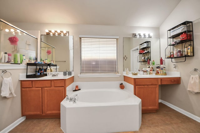 bathroom with a bath, tile patterned floors, two vanities, and vaulted ceiling