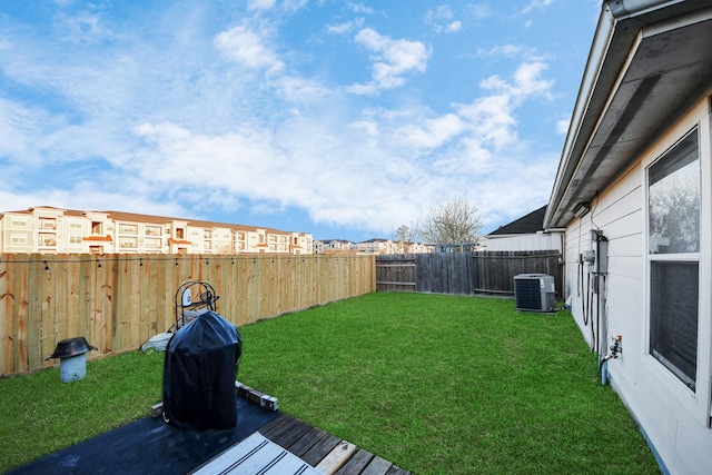 view of yard with a fenced backyard, a residential view, and central AC