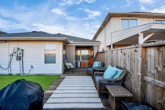 rear view of property featuring fence and a wooden deck