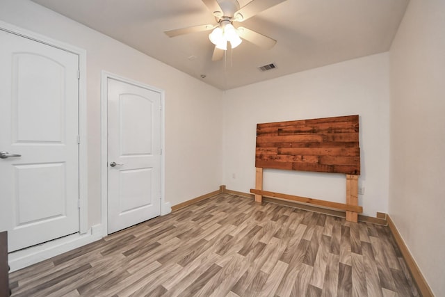 spare room with visible vents, baseboards, ceiling fan, and light wood finished floors