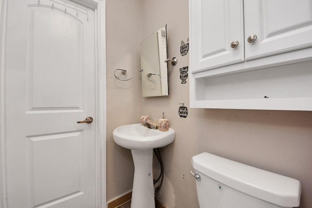 half bathroom featuring toilet and a sink