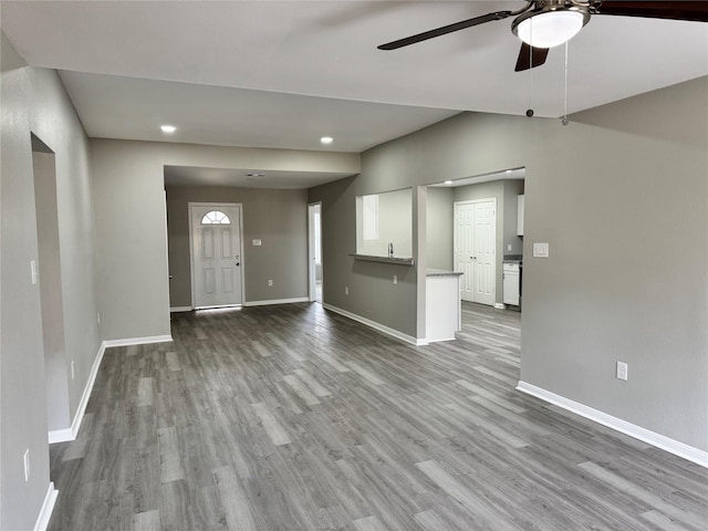 unfurnished living room with dark wood-type flooring, recessed lighting, a ceiling fan, and baseboards