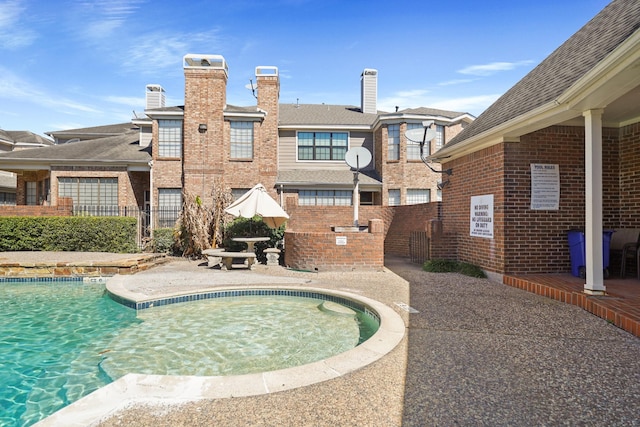 view of swimming pool featuring a patio and fence