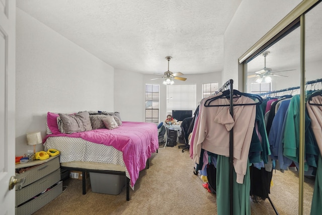 carpeted bedroom featuring a textured ceiling and ceiling fan