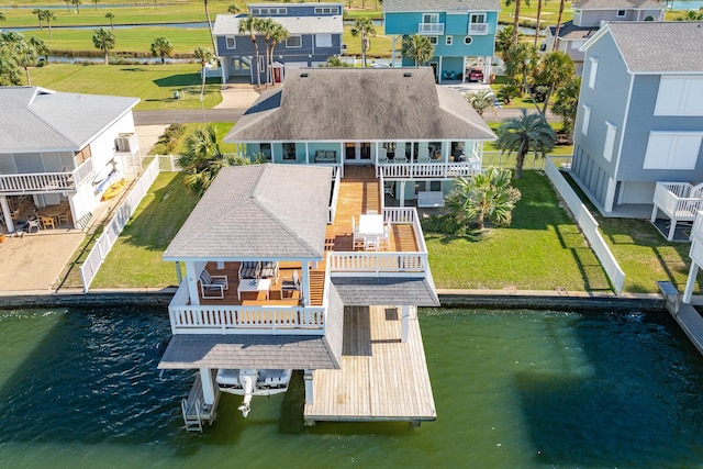 exterior space featuring a residential view, a water view, and a lawn