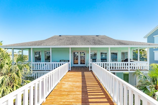 exterior space featuring french doors and a shingled roof