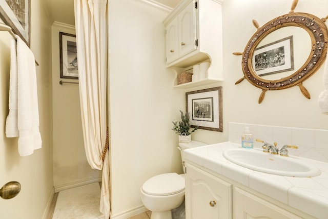 bathroom featuring baseboards, toilet, and vanity