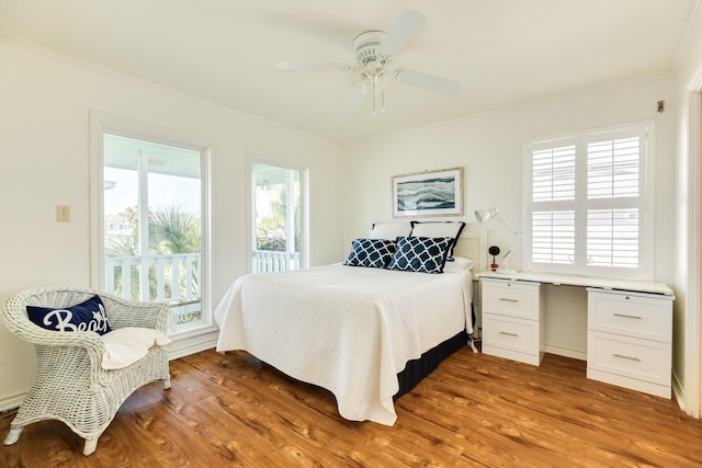 bedroom with multiple windows, crown molding, and wood finished floors