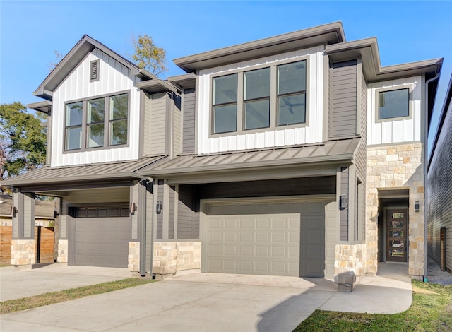 view of front of home featuring stone siding, board and batten siding, an attached garage, and a standing seam roof