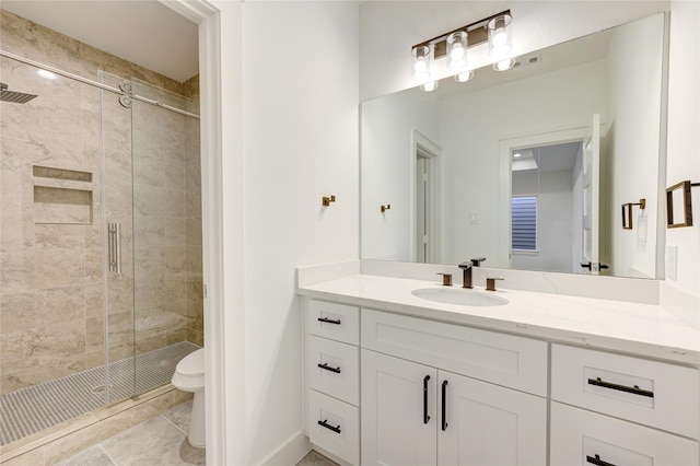 bathroom with baseboards, toilet, a stall shower, and vanity