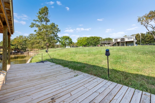 wooden deck with a lawn and a water view