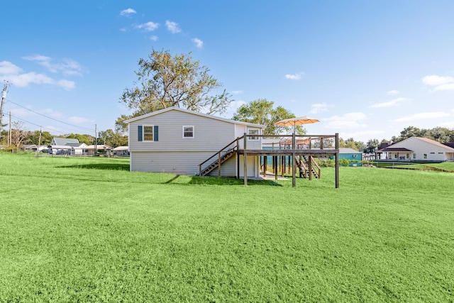 back of house with stairway, a lawn, and a wooden deck