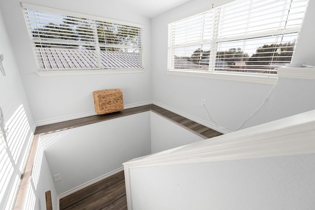 staircase featuring wood finished floors and baseboards