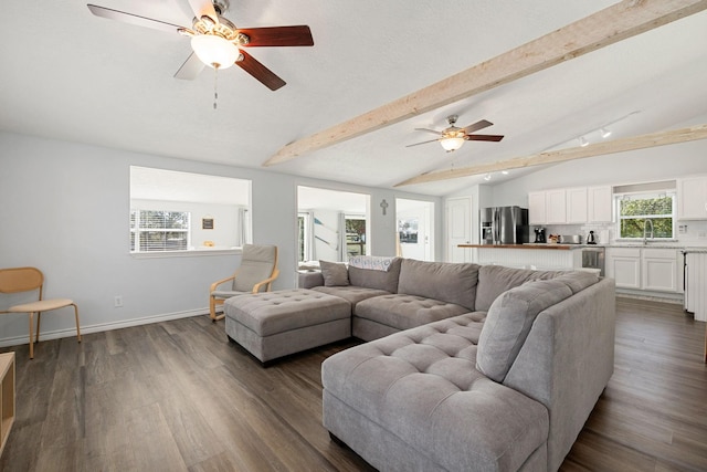 living room featuring baseboards, a ceiling fan, dark wood-style floors, and vaulted ceiling with beams