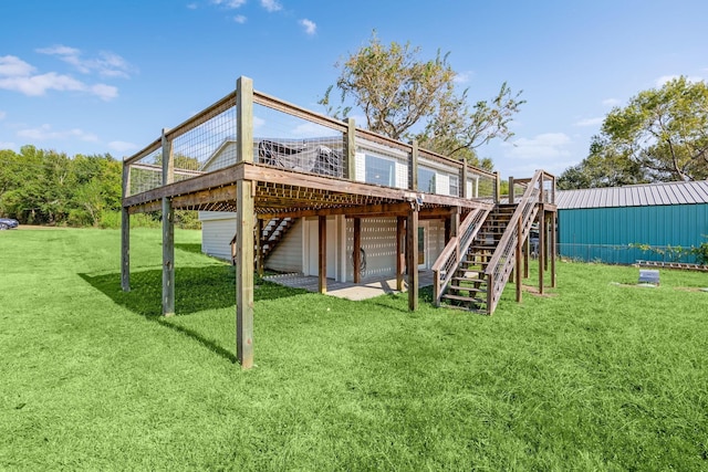 rear view of property with stairway, a lawn, and a wooden deck