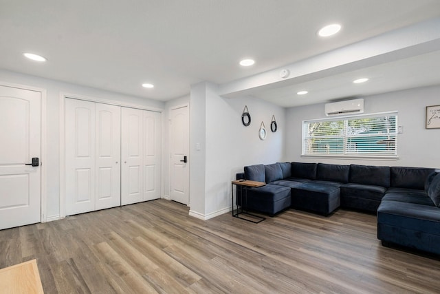 living room featuring light wood-style flooring, recessed lighting, baseboards, and a wall mounted air conditioner