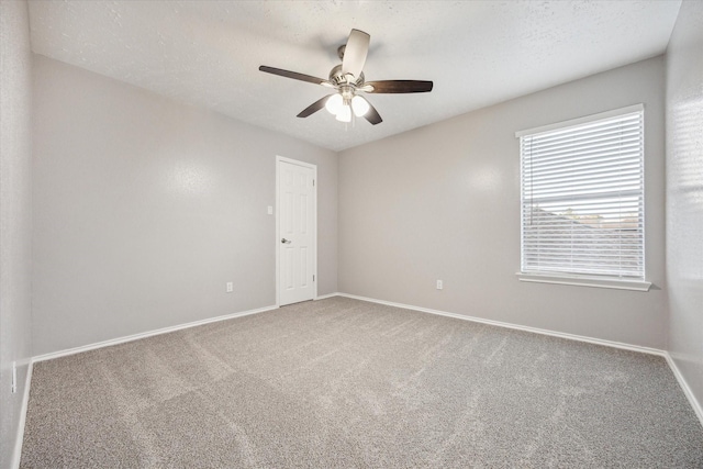 carpeted empty room featuring a textured ceiling, baseboards, and ceiling fan