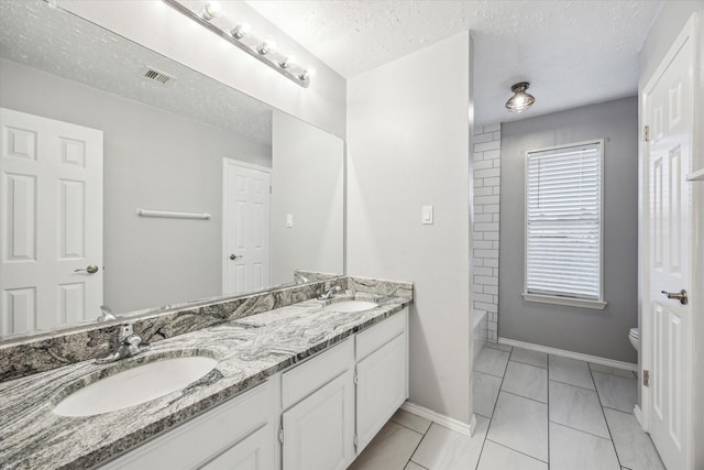 bathroom featuring double vanity, toilet, visible vents, and a sink