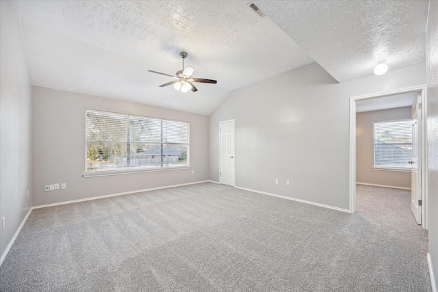 carpeted spare room with visible vents, a ceiling fan, a textured ceiling, baseboards, and lofted ceiling