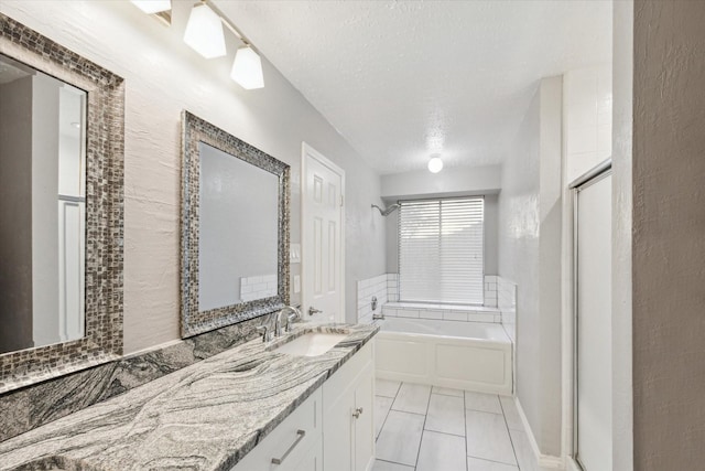 full bath featuring vanity, a stall shower, tile patterned flooring, a textured ceiling, and a garden tub