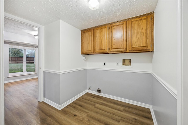 washroom with electric dryer hookup, cabinet space, hookup for a washing machine, and dark wood-style flooring