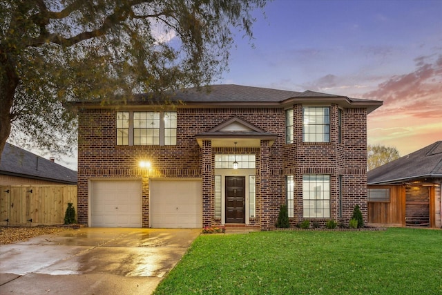 view of front of house with a front yard, brick siding, an attached garage, and fence