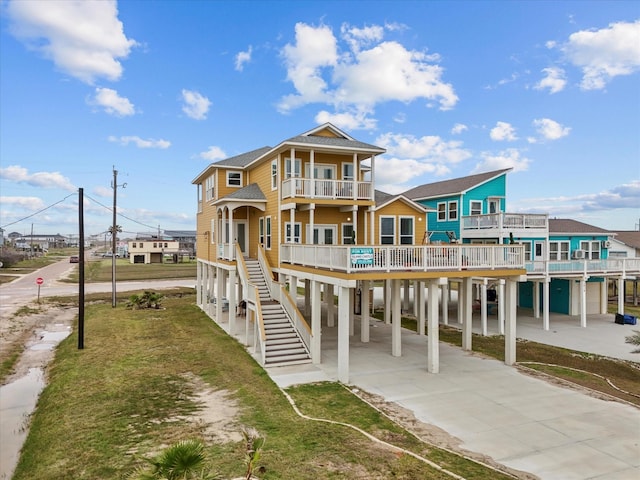 1018 Seashell Dr, Surfside Beach, TX 77541 - view of front of house featuring a balcony, a carport, concrete driveway, and a front lawn