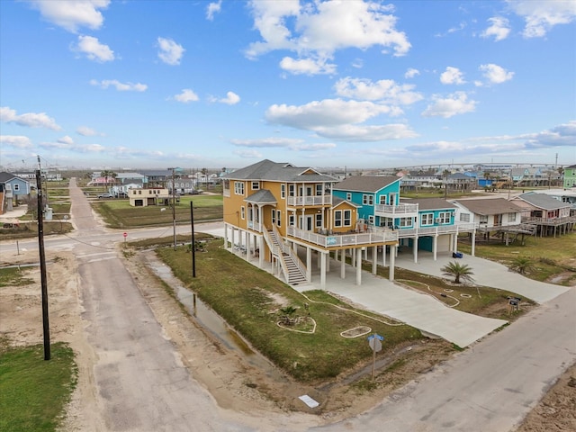 1018 Seashell Dr, Surfside Beach, TX 77541 - rear view of house featuring a carport, driveway, stairway, a balcony, and a residential view