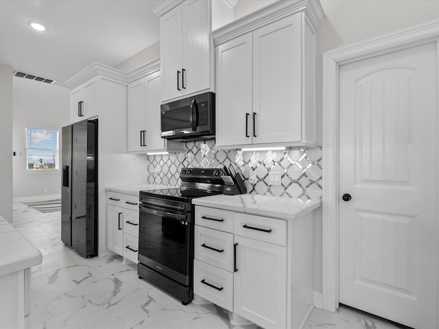 kitchen featuring decorative backsplash, white cabinets, stainless steel fridge, marble finish floor, and black / electric stove