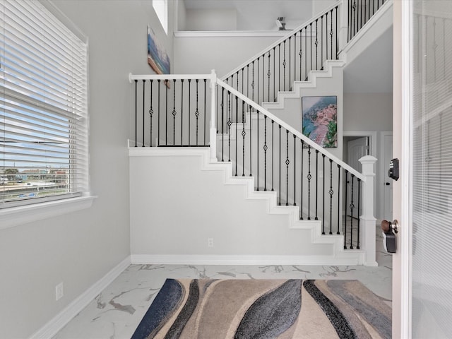 staircase featuring baseboards and marble finish floor